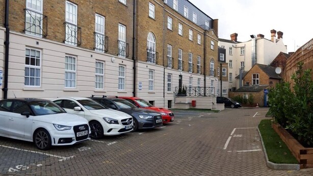 A row of townhouses with a parking area in front. - Riverside 4 (Maidstone)