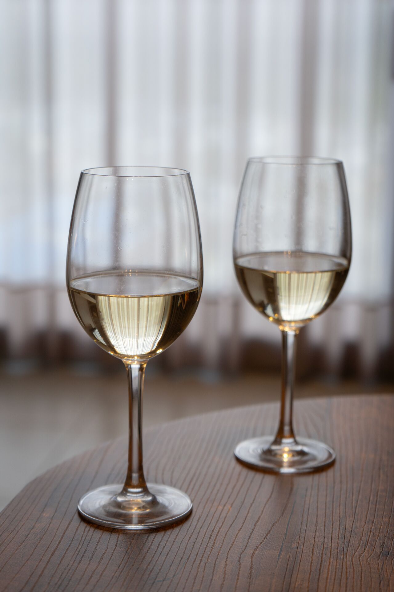 Two wine glasses on a wooden table.