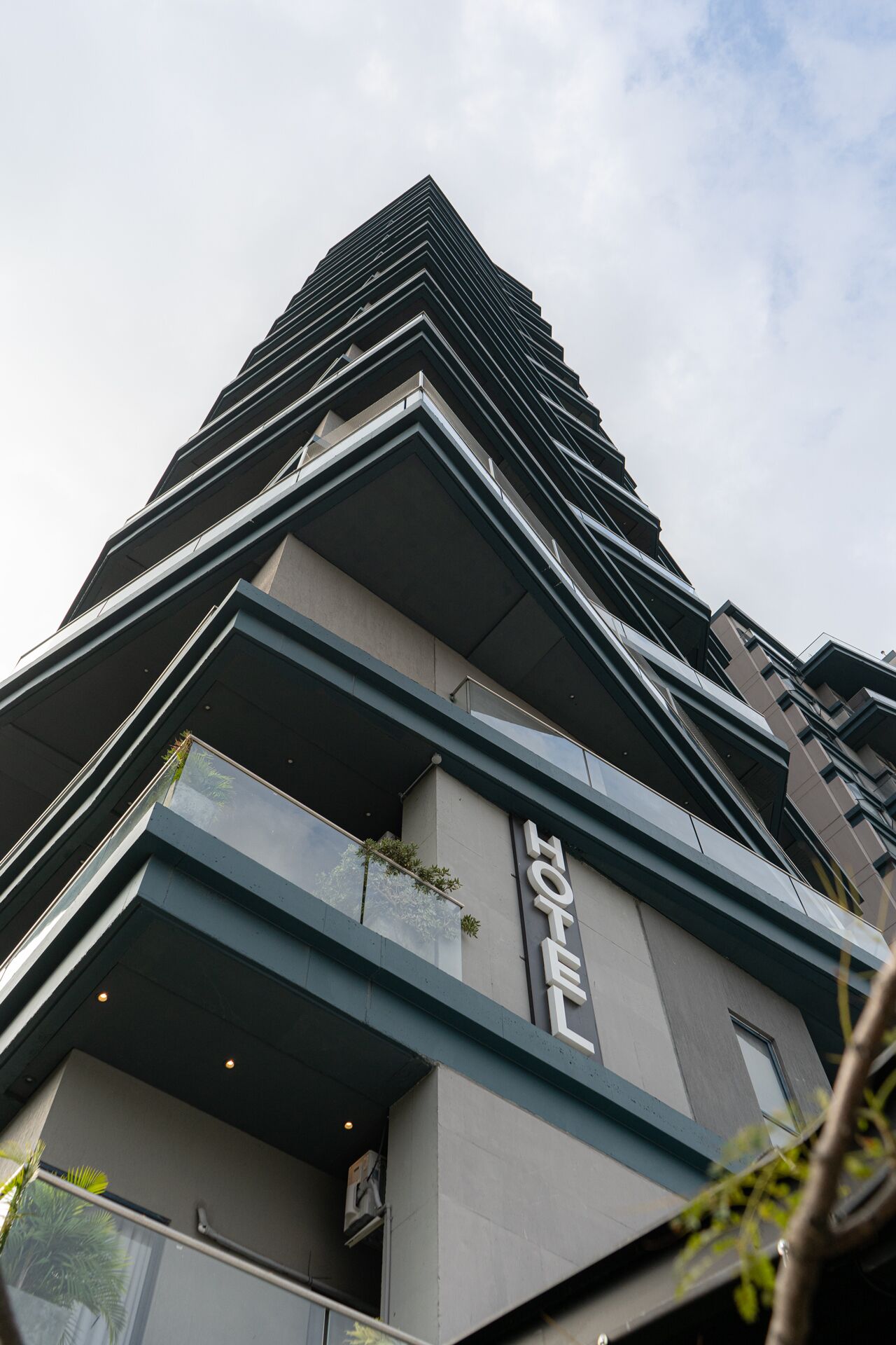 Un edificio moderno de gran altura con un llamativo letrero que dice 'HOTEL' en la fachada.