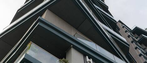 Un edificio moderno de gran altura con un llamativo letrero que dice 'HOTEL' en la fachada.