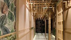 A hallway with wooden paneling, a mirrored wall, and a tiled floor. - FR Hotel (Ibagué)