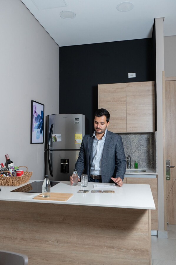 Una cocina moderna con una isla central, un refrigerador y armarios de madera.