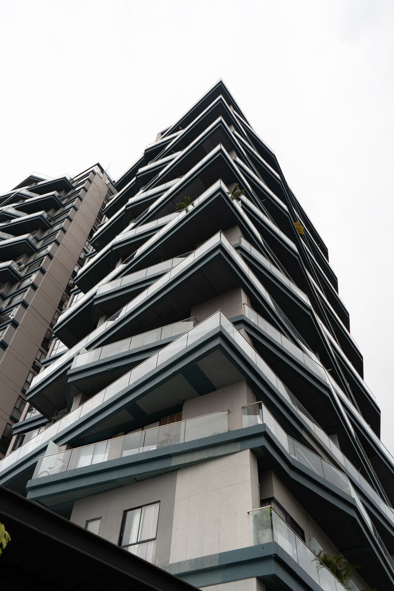 Ein modernes Hochhaus mit einer Zickzack-Fassade und Balkonen.
