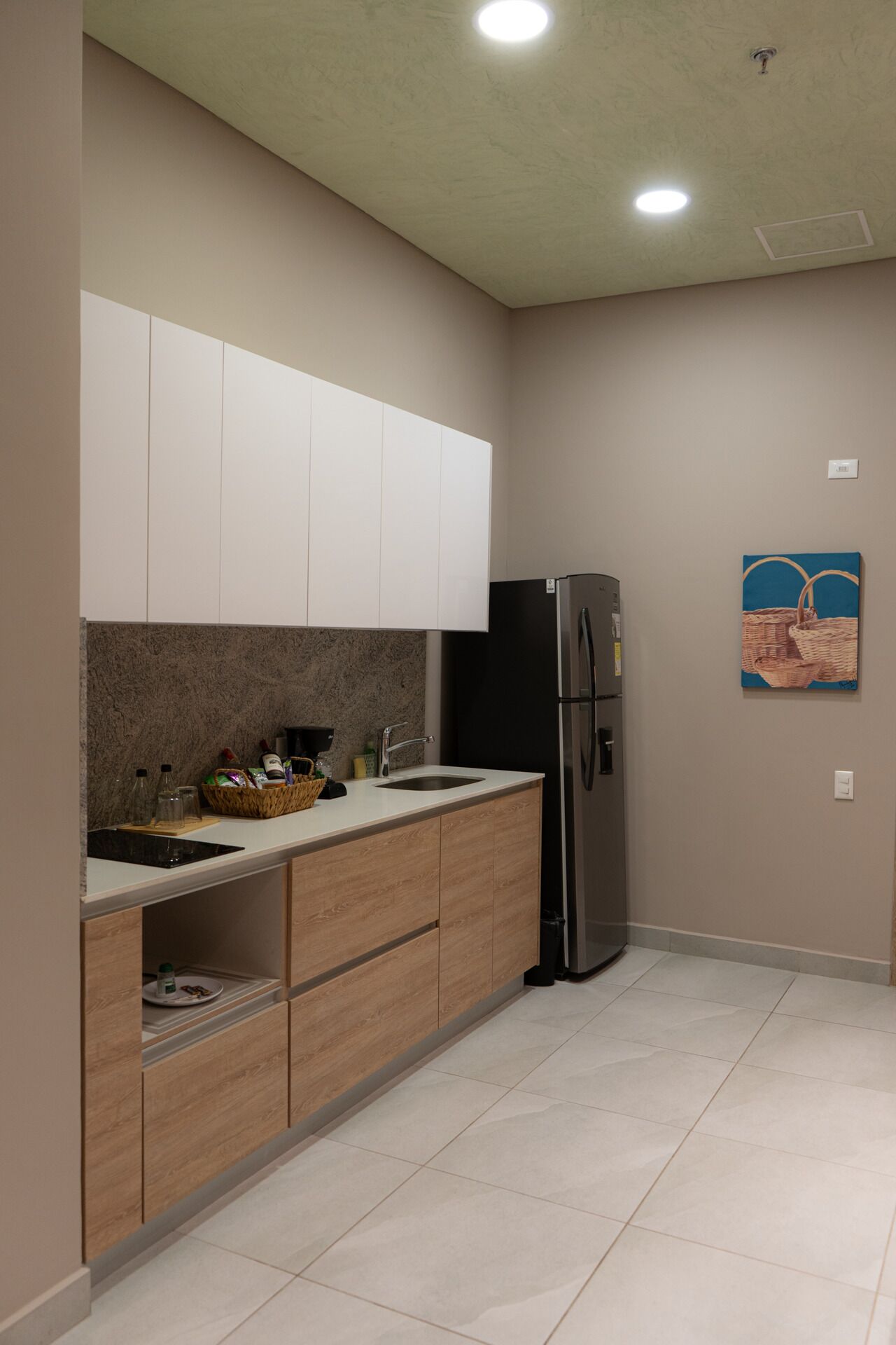 A modern kitchen with a built-in refrigerator, a sink, and wooden cabinets.