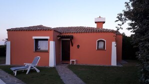A house with a tiled roof, a small front porch, a lawn, and a pool. - Villa Camilla private garden and pool. 30% DISCOUNT, PERIOD 24 MAY - 7 JUNE (Punta de Su Turrione Stintino ( SS))