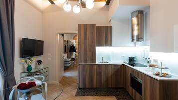 A modern kitchen with wooden cabinets, a built-in oven, and a stainless steel range hood.