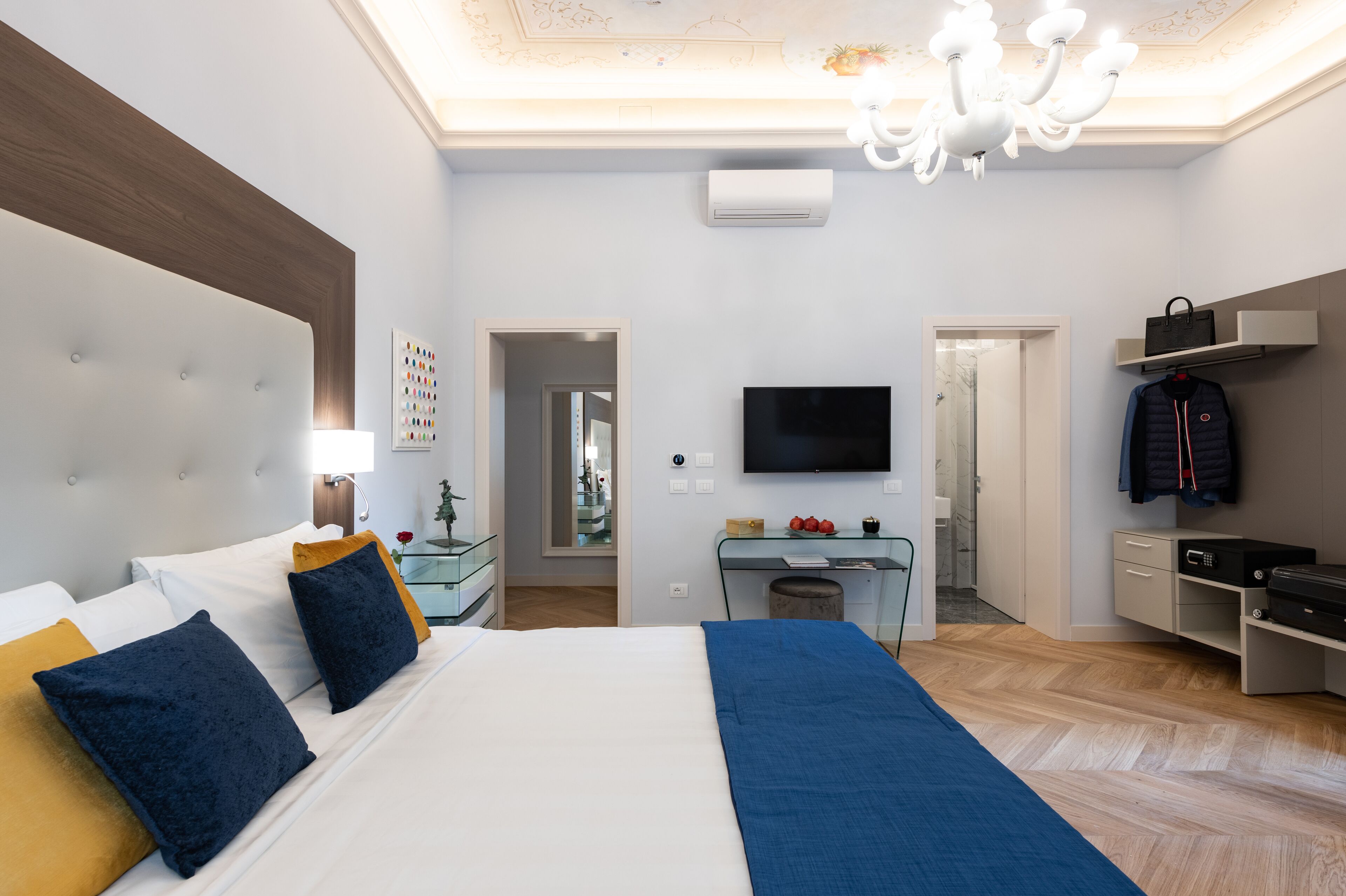 Une chambre d’hôtel moderne dotée d’un grand lit, d’une télévision à écran plat, d’un bureau et d’une armoire.