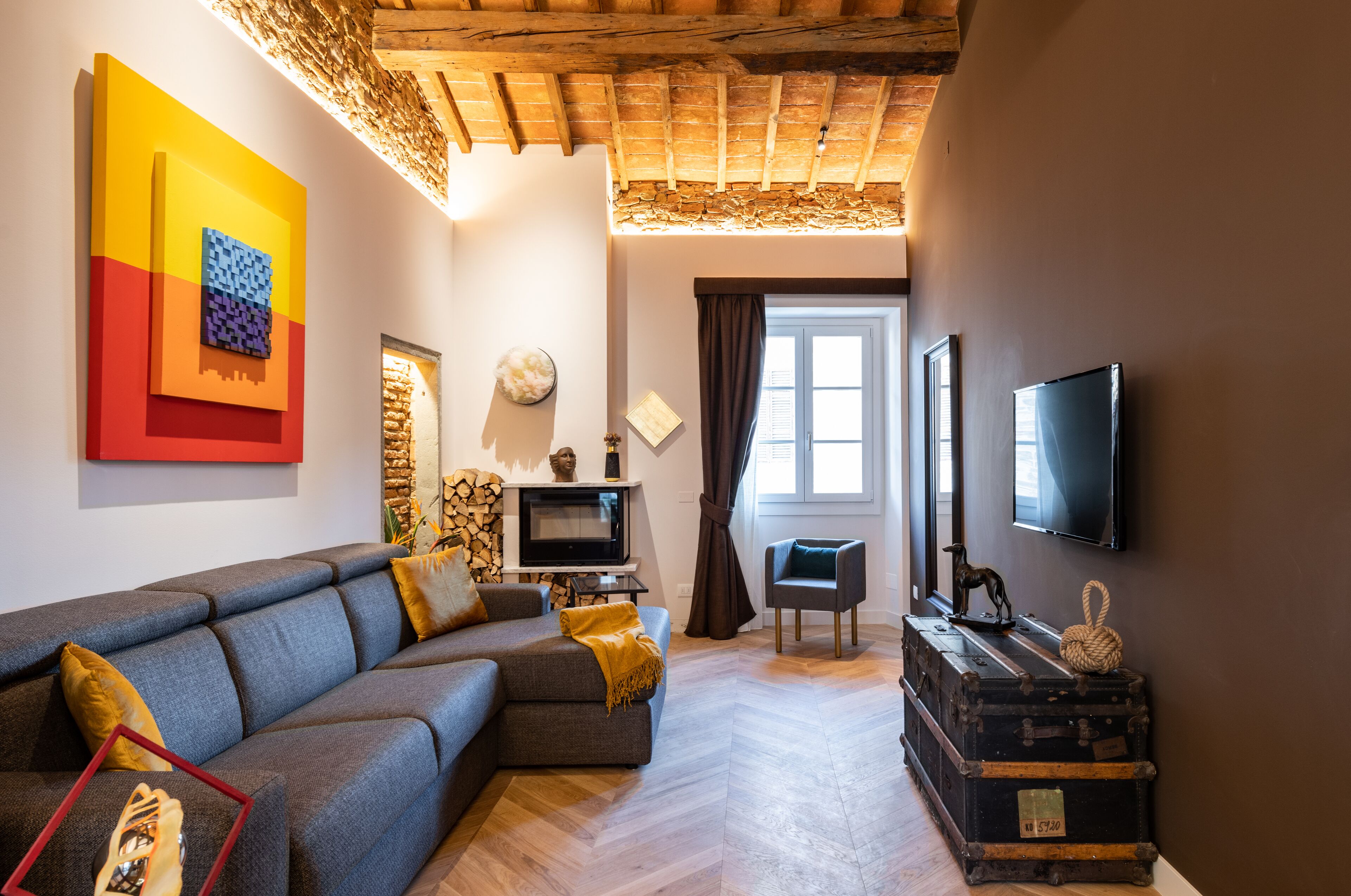 Una sala de estar moderna con un sofá modular, un televisor de pantalla plana y una chimenea.
