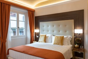 A hotel room with a large bed, a nightstand with a lamp, and a window with curtains. - Kairos by Florence Art Apartments (Florence)