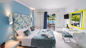 A bedroom with a bed, bedside table, and a view of a pool and outdoor seating area. - Sunny Garden (Lefkada)