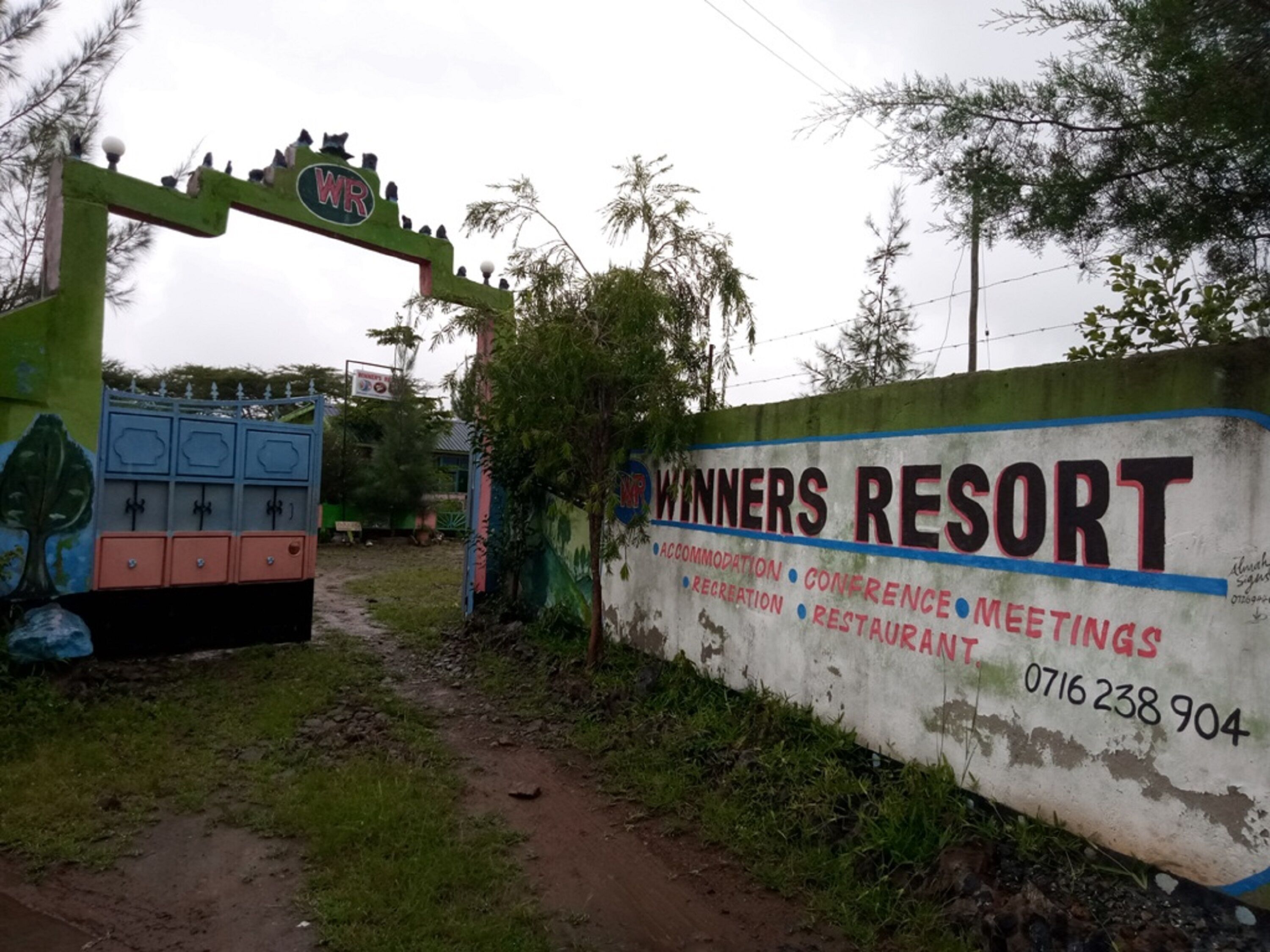 A sign for Winners Resort with amenities listed including accommodation, conference, recreation, and restaurant.