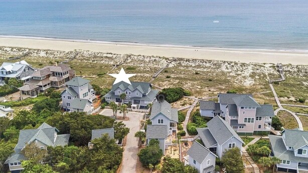 Un quartier résidentiel situé sur la côte, avec des maisons, une plage et un symbole en forme d’étoile.