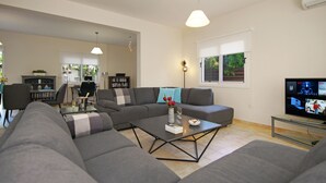 A modern living room with a sectional sofa, a coffee table, and a television. - VILLA CLEOPATRA  - 4bed Villa with large pool in Ayia Napa Hills (Paralimni)