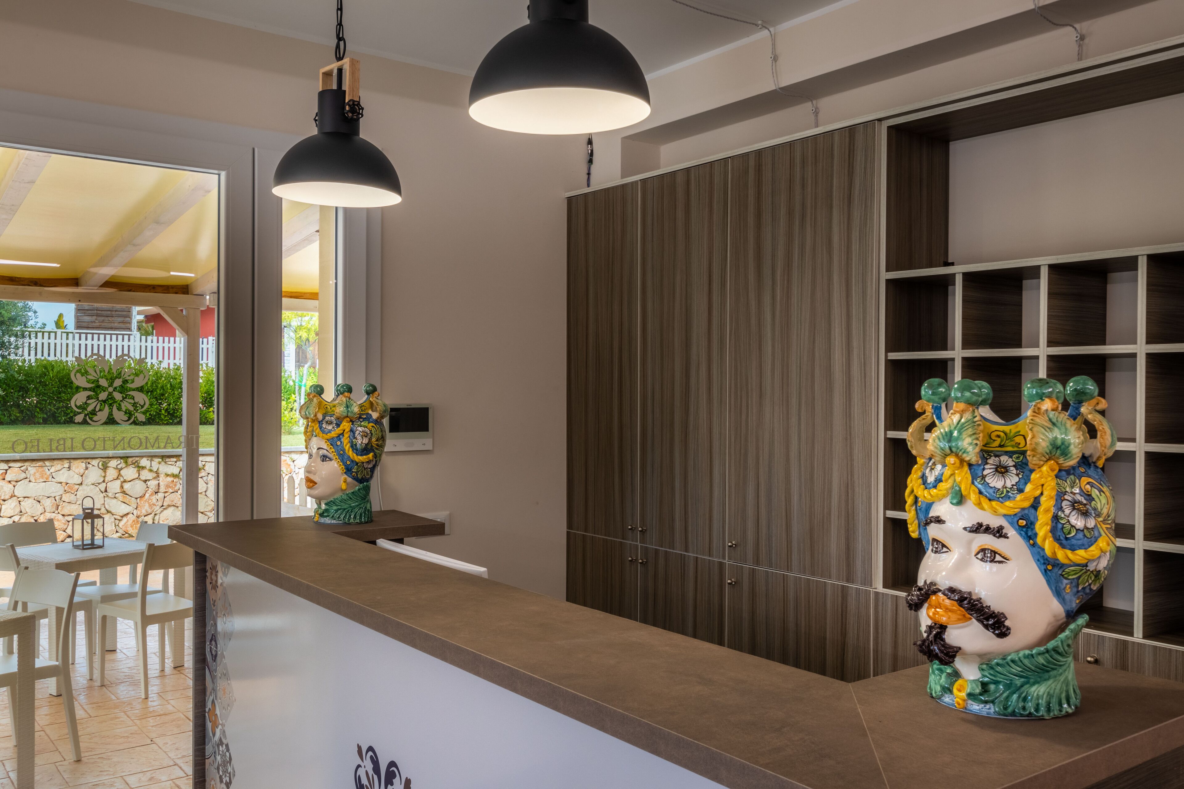 Una cocina moderna con armarios de madera, encimera de mármol y jarrones decorativos.