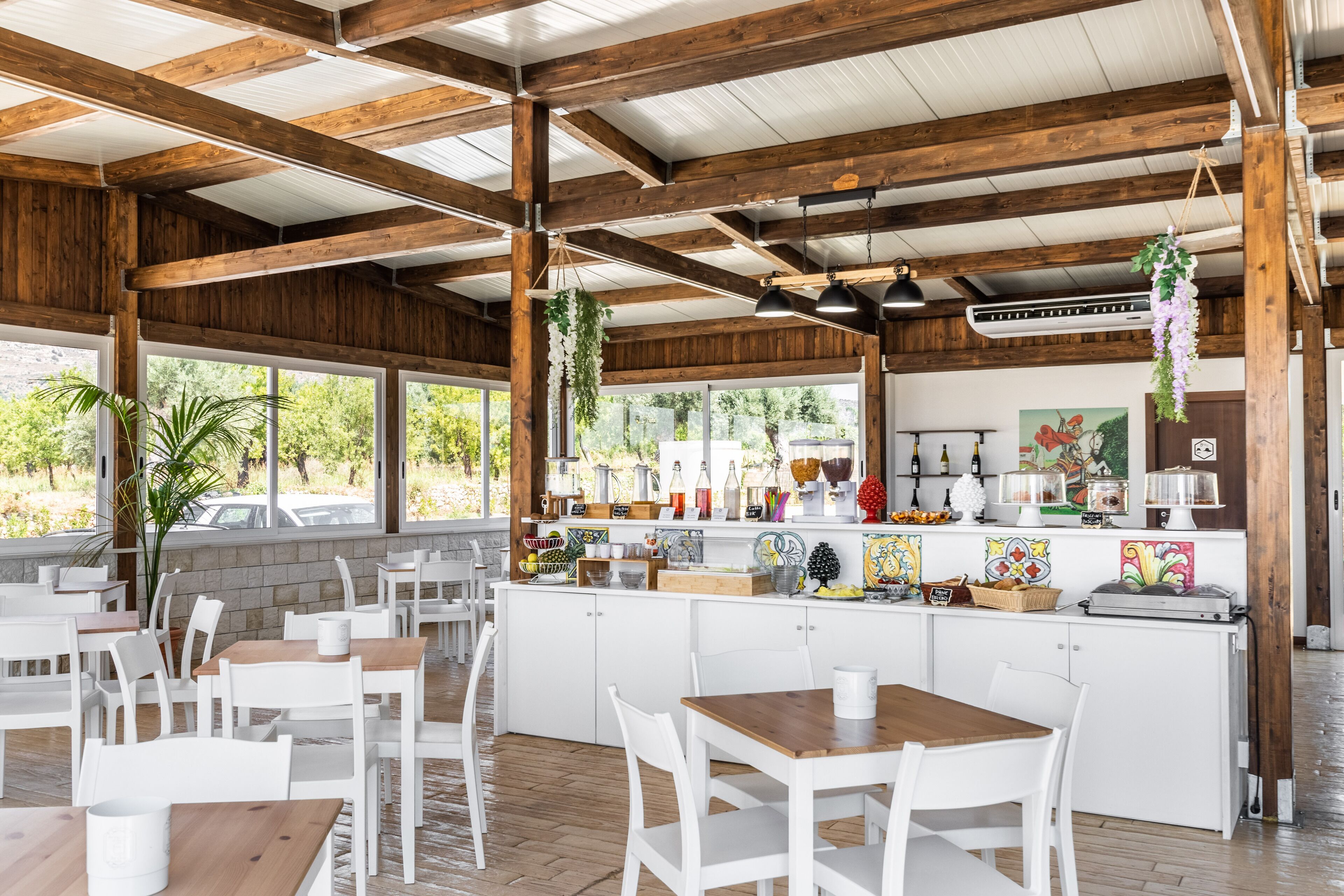 Un ristorante con travi in legno, arredi bianchi e un bancone con diversi articoli.