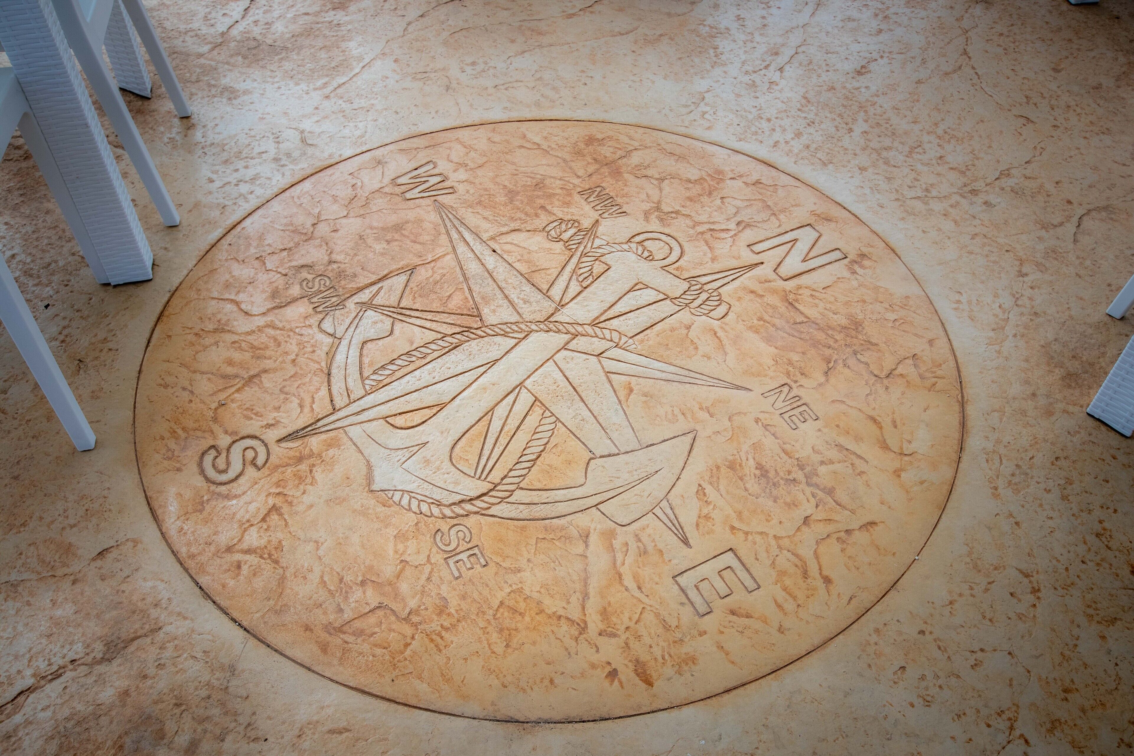 A compass rose etched into a circular floor tile.