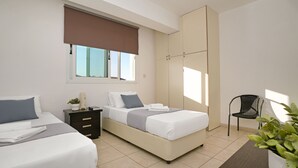 Une chambre moderne avec deux lits, une table de chevet, une chaise et une grande fenêtre donnant sur un beau paysage.