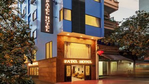 Hotellin julkisivu on sininen, siinä on useita ikkunoita ja kyltti, jossa lukee: ”Pateel Hotel”.