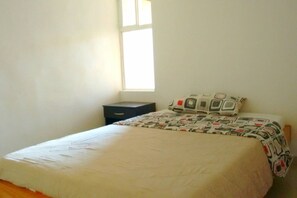 A bedroom with a single bed, a small bedside table, and a window. - Private 501 with bathroom, TV closet and WI-FI (Bello)