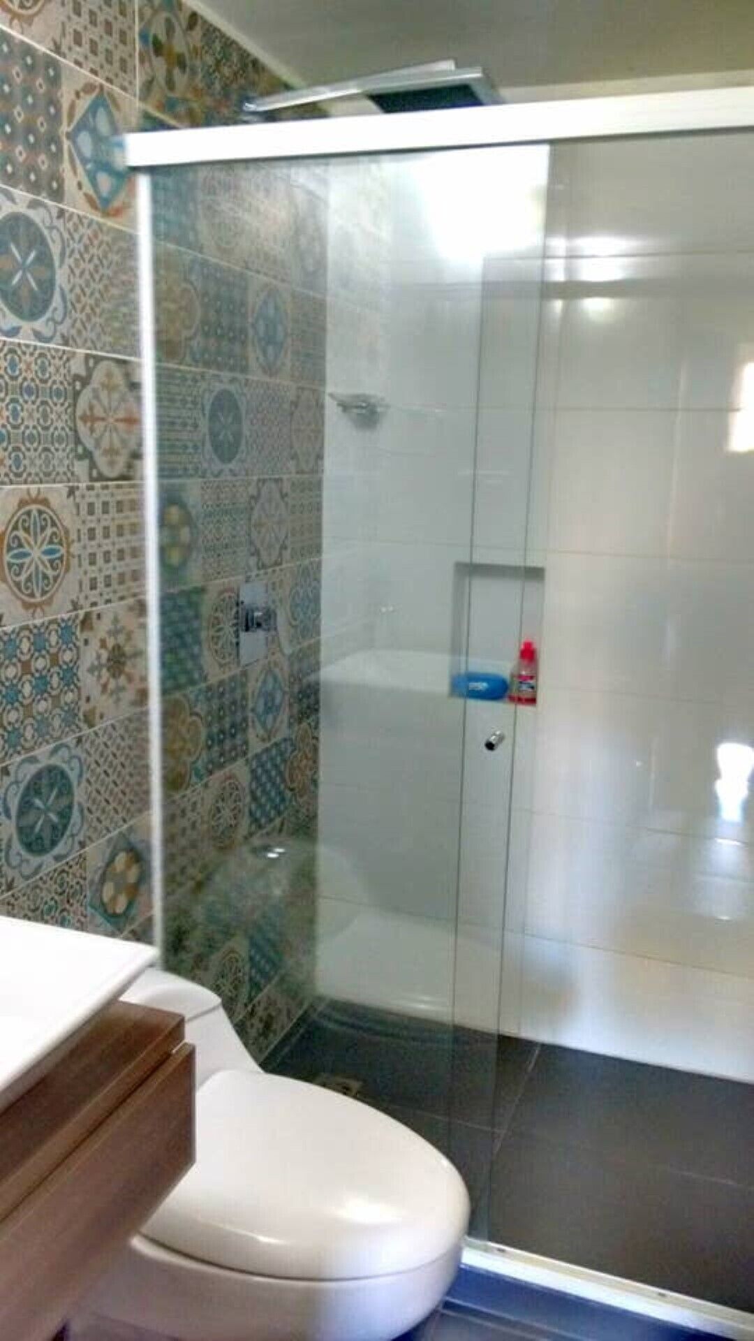 Un baño con cabina de ducha, inodoro y lavabo.