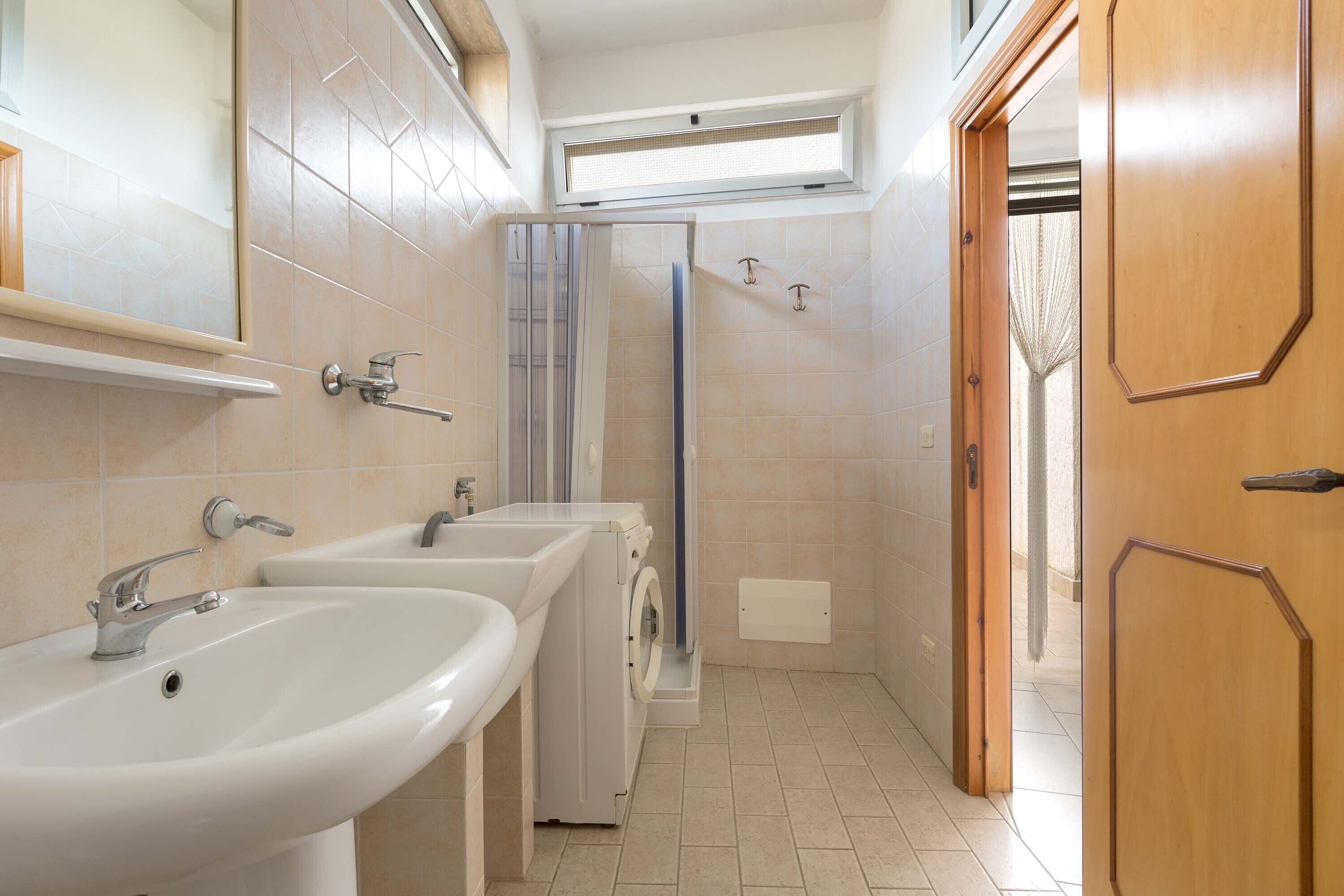 A bathroom with two sinks, a shower, and a toilet.