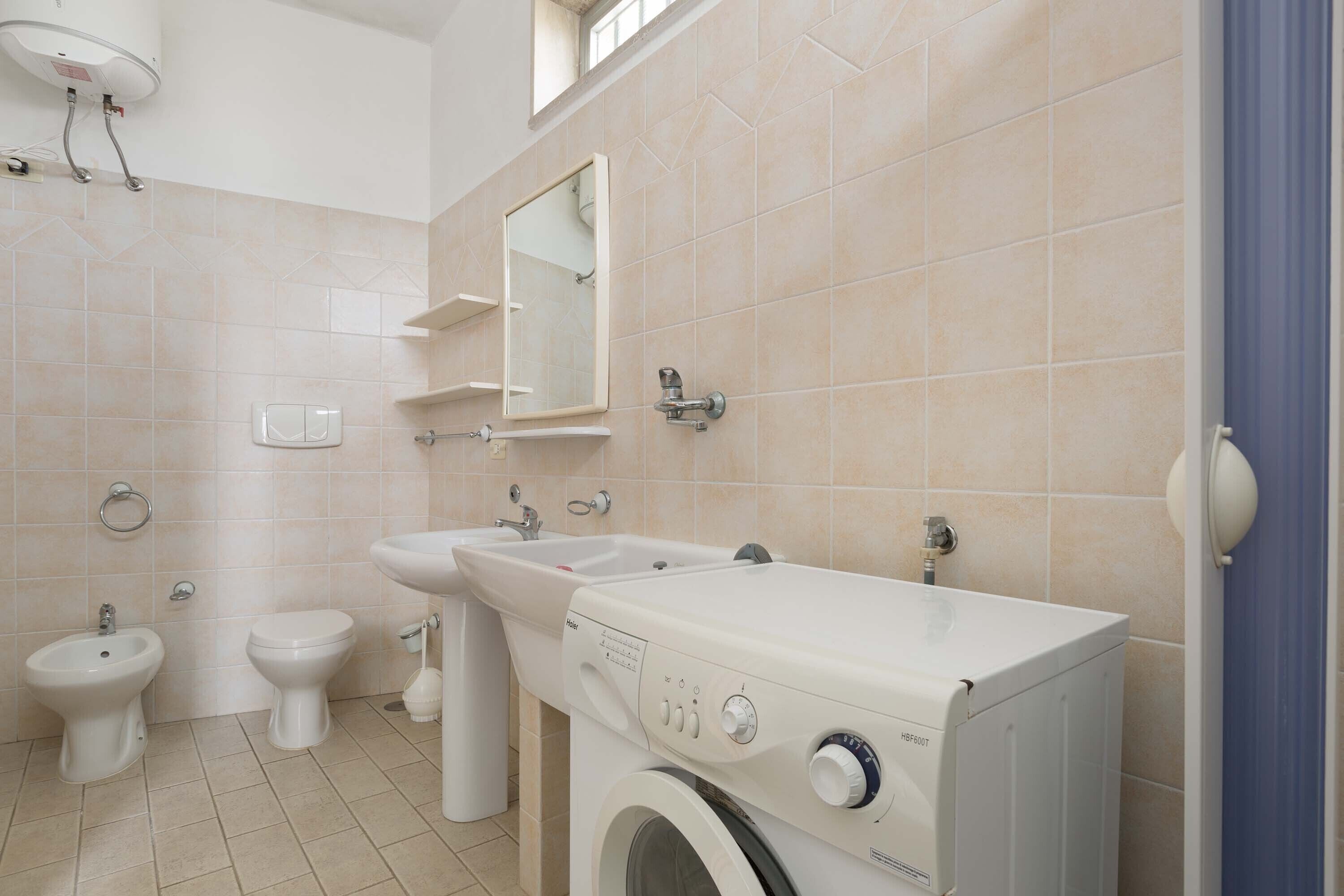 Un baño moderno con lavadora, bidé y lavamanos.