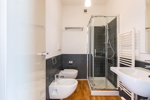 A modern bathroom with a glass-enclosed shower, a white sink, and a toilet. - Le Dune Villas (Porto Cesareo)