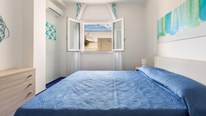 A bedroom with a bed, a dresser, and a window with curtains. - Residence Spiaggia d'Oro (Porto Cesareo)