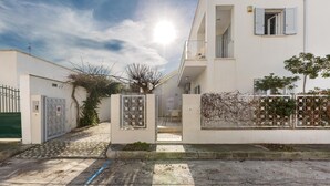 A residential building with a gated entrance, a balcony, and a clear sky. - Residence Spiaggia d'Oro (Porto Cesareo)