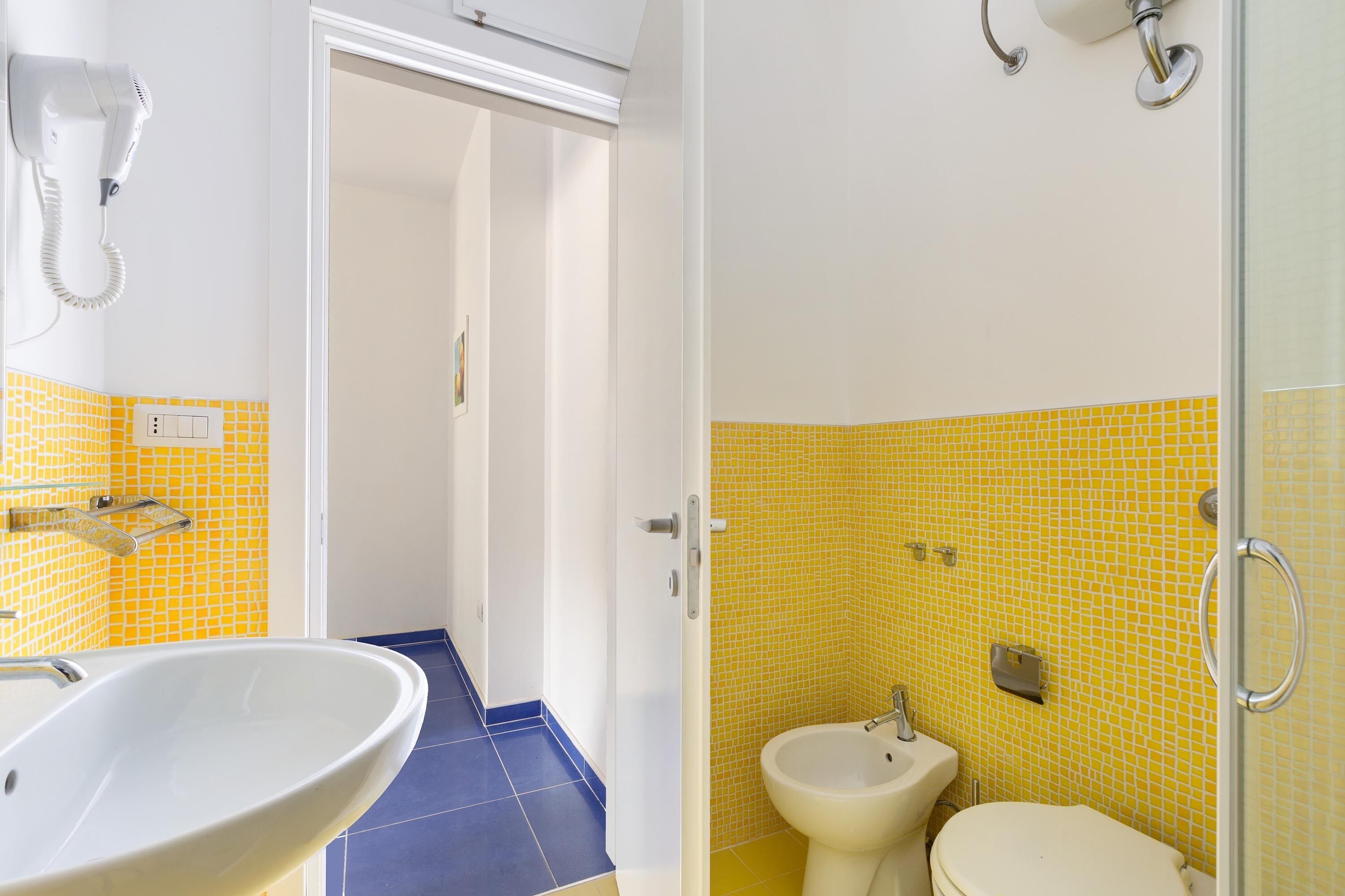 Un baño con un lavamanos blanco, un bidé y un inodoro.