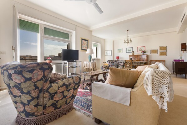 Una sala de estar con sofá, sillón y televisor.