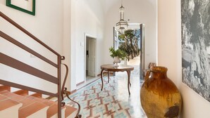 A hallway with a patterned floor, a large vase, and a framed picture on the wall. - Villa Thea Charming House (Carovigno)