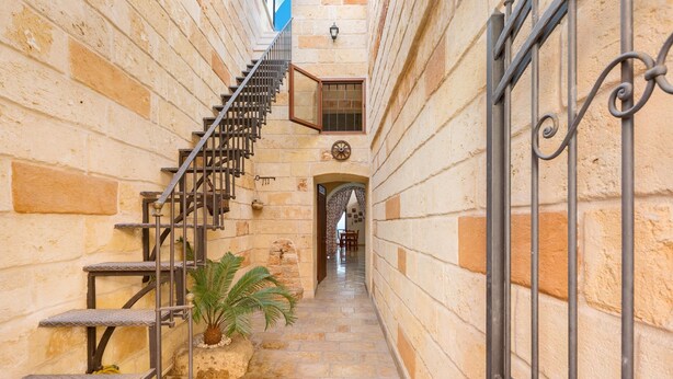 A narrow stone corridor with a metal staircase leading to an upper level. - La Nicchia di Luana (Copertino)