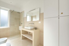 A modern bathroom with a glass-enclosed shower, a white sink, and a large mirror. - Villa Zena (Carovigno)