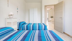 A bedroom with two beds, a dresser, and a wardrobe. - Casa Medusa (Torricella)
