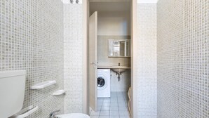 A compact bathroom with a toilet, sink, and washing machine. - Casa Medusa (Torricella)