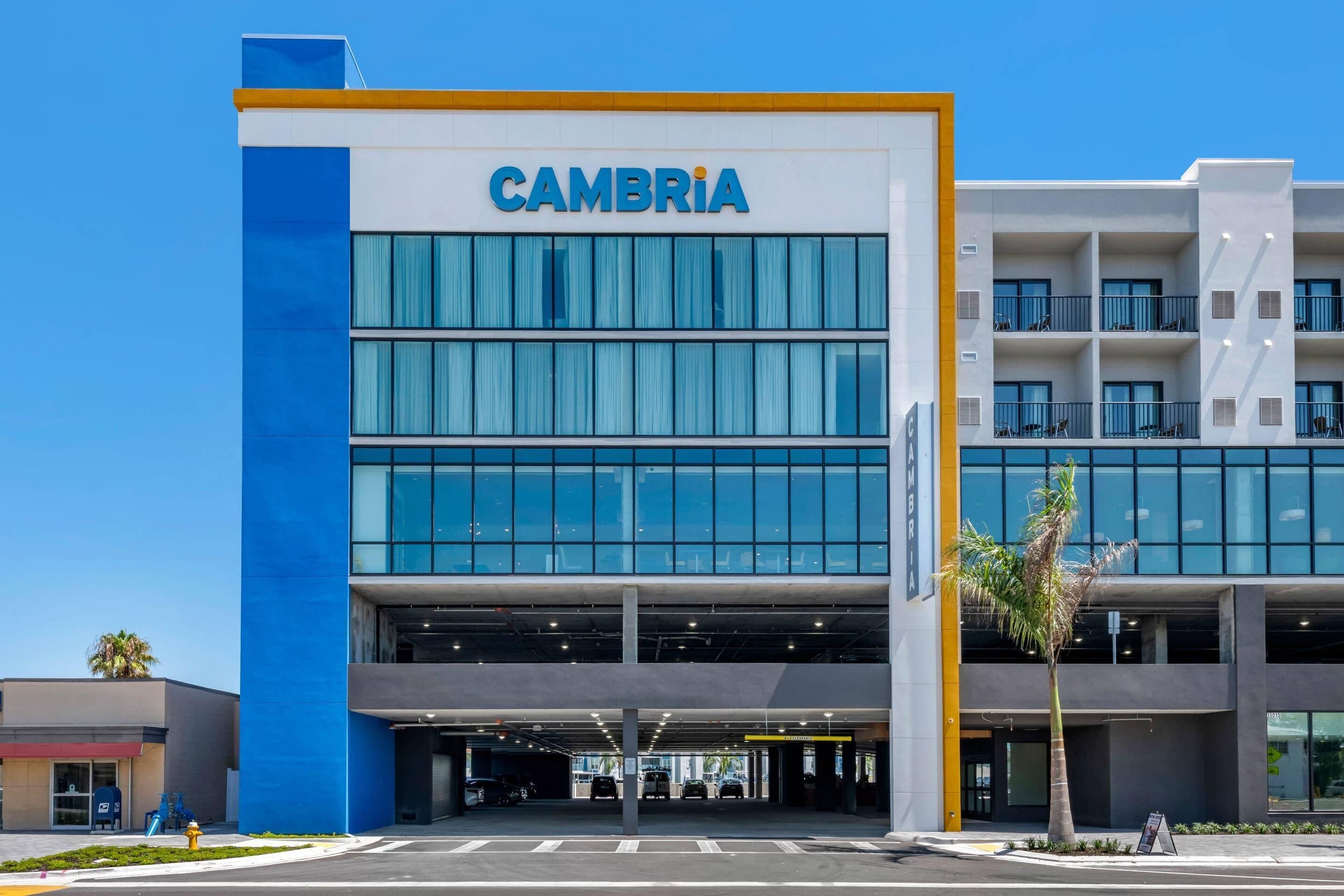 Il s'agit d'un bâtiment moderne sur lequel le nom « CAMBRIA » est clairement affiché. Il se caractérise par une structure à plusieurs étages, de grandes fenêtres et un toit plat.