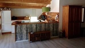 A kitchen with wooden beams, a wooden counter, and a built-in bench. - Landhaus Chlosta (Biendorf)