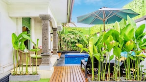 A patio area with a pool, wooden deck, and lush greenery. - VILLA RETRO 88 - Short Walk to Beach - Top Located (Seminyak)