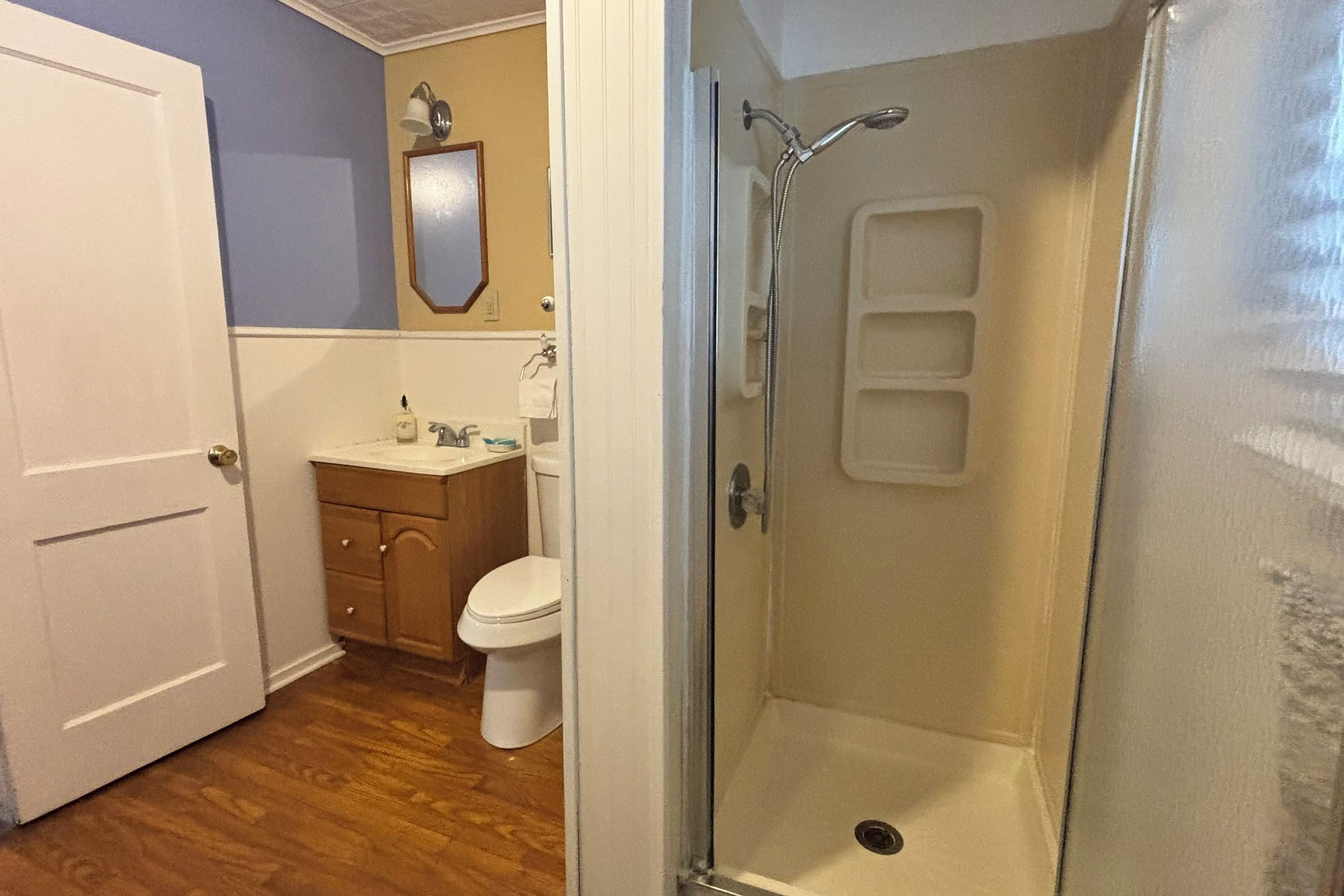 Une salle de bain avec douche, toilettes et lavabo.