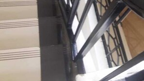 A staircase with a metal railing and a wooden floor. - Royal Palm Hotel And Suites (Nakuru)
