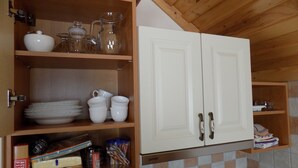 A kitchen with wooden cabinets, a tiled backsplash, and various kitchenware.