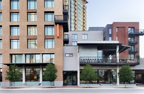A multi-story building with a mix of brick and modern architectural styles, featuring large windows and balconies.