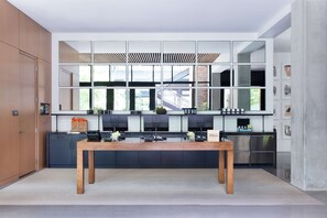 A modern kitchen with a central island, built-in appliances, and a large window overlooking the city.