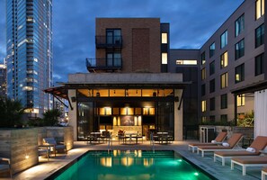 A rooftop pool area with lounge chairs and a bar, surrounded by modern buildings. - Canopy by Hilton Austin Downtown (Austin)