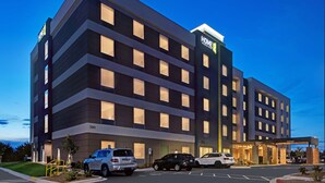 A modern hotel with a flat facade, multiple windows, and a prominent 'Home2' sign.