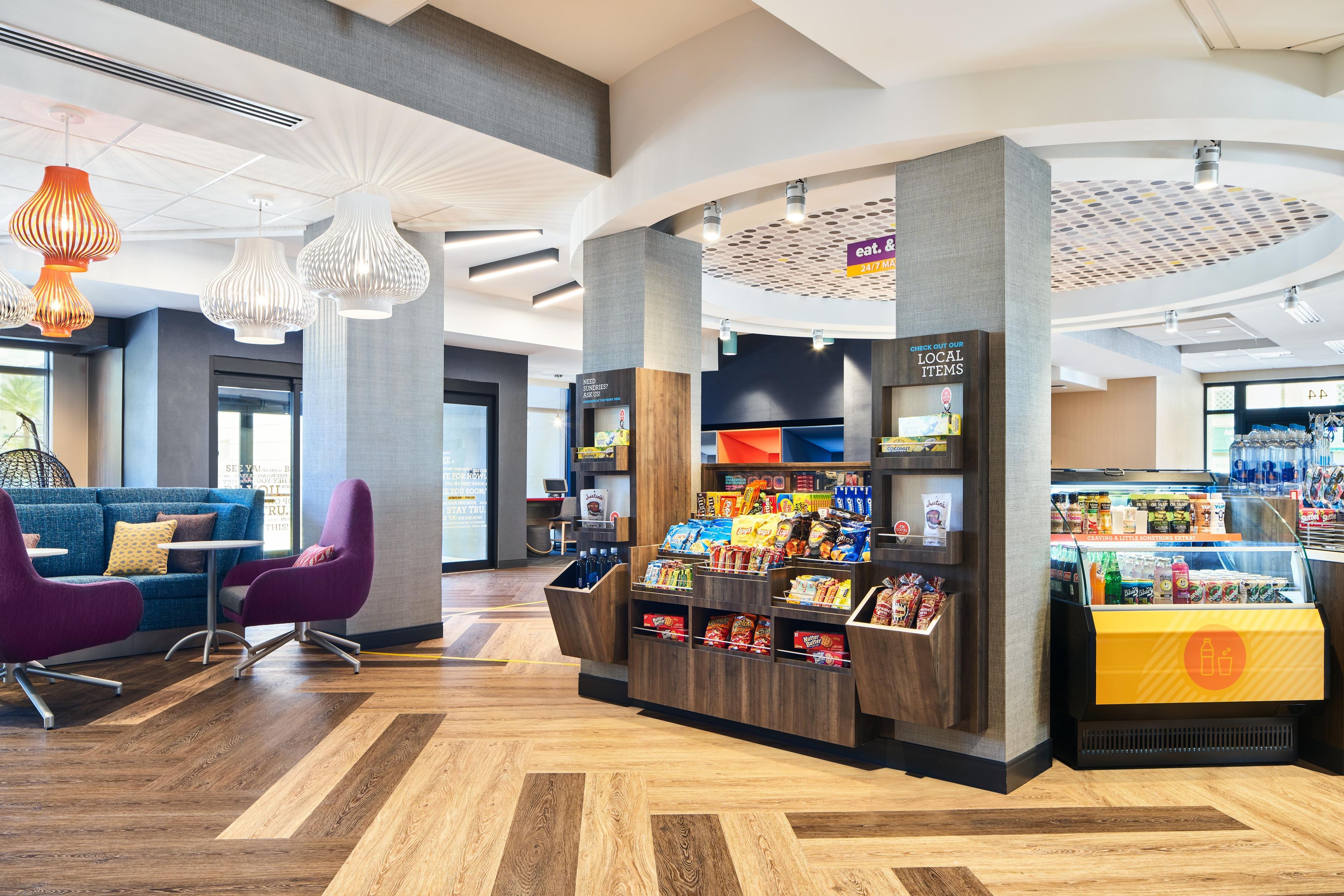 Un intérieur moderne comprenant un espace salon, un bar servant des collations et un comptoir de caisse.