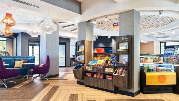 A modern interior with a seating area, a snack bar, and a refrigerated section.