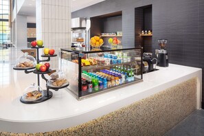 A self-service breakfast station with a variety of pastries, fruits, and beverages. - Canopy by Hilton Grand Rapids Downtown (Grand Rapids)