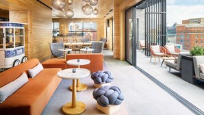 Un intérieur moderne avec des murs en bois, un espace bar et différents types de sièges.
